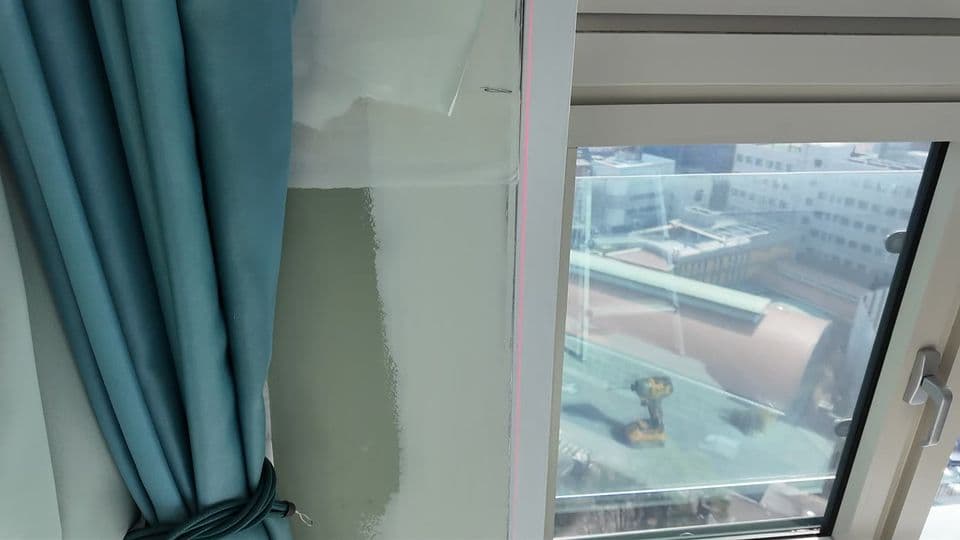 성수동 서울숲힐스테이트 35평 덧창 샷시 시공 — 측정기가 샷시 옆 벽에 비춘 붉은 세로선