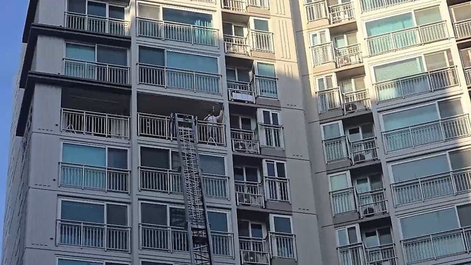 아파트 샷시 교체 현장의 사다리차 창호 양중 작업