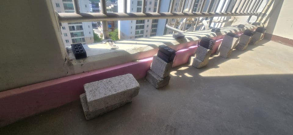 용인 죽전 건영캐스빌 42평 샷시 교체 — 새 샷시를 앉히기 전 창틀 하부. 분홍 단열재를 대고 조적벽돌과 검은 세팅블록을 놓아 두었어요