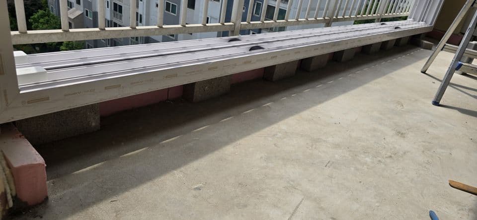 용인 상현동 만현마을1단지롯데캐슬 37평 샷시 교체 — 새 샷시 틀 하부를 조적벽돌로 받쳐 둔 모습